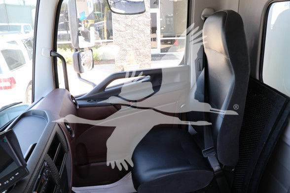 Cab interior of a 2025 Hino L6 truck showing driver's seat, steering wheel, and dashboard.