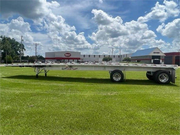 Flatbed trailer showing all-aluminum 48ft deck with dual axles and aluminum frame.