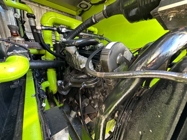 Ford F550 engine bay showing bright green fire apparatus with engine components and hoses visible.