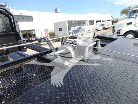 Mack MD6 tow truck platform showing winch assembly and diamond plate surface with metal rails.