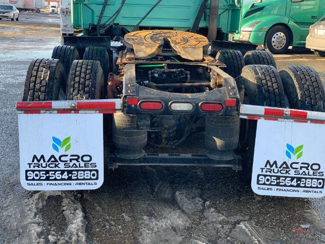Rear view of a 2015 Volvo VNL 670 truck chassis with fifth wheel and dual rear wheels, showing mud flaps labeled Macro Truck Sales and contact number.