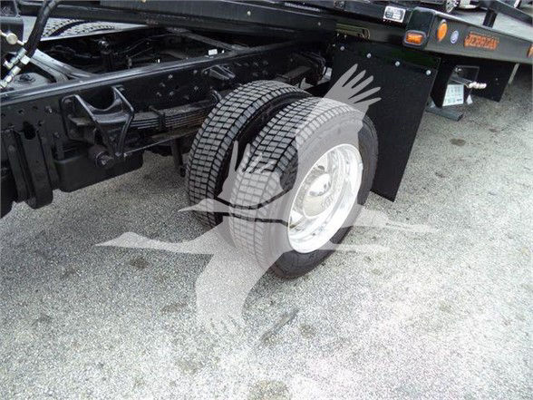 Truck rear wheel and chassis of a 2023 International CV tow truck showing dual rear tires and suspension components.