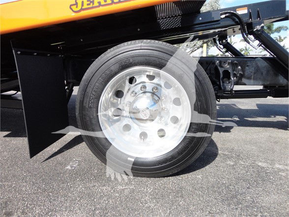Wheel and front suspension of a Peterbilt 337 tow truck showing a polished aluminum wheel and tire.