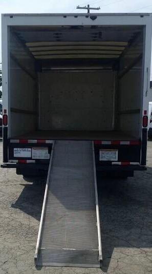 Truck rear view with open cargo box and lowered aluminum ramp. GMC Savana 3500 box truck cargo area visible.