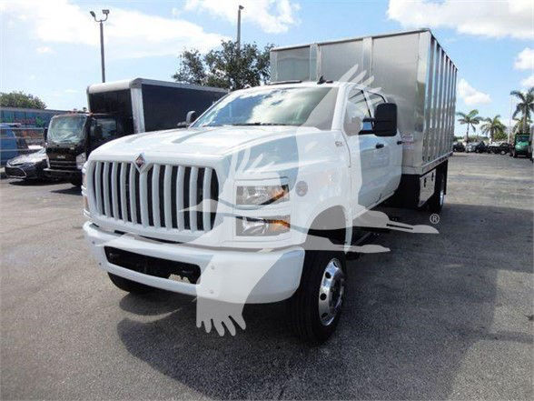 International CV dump truck in white with box dump bed, front grille, headlamps visible.