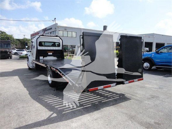 Freightliner BUSINESS CLASS M2 106 tow truck with flatbed and rear wheel fenders visible