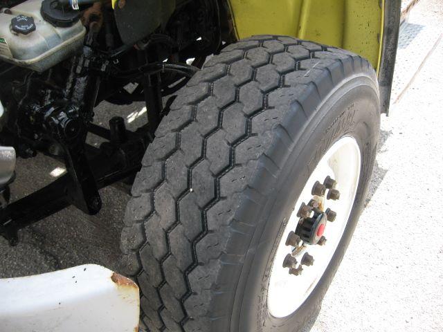 Truck front wheel and engine bay of a 2008 Freightliner M2106 cab and chassis showing large front tire and wheel hub.
