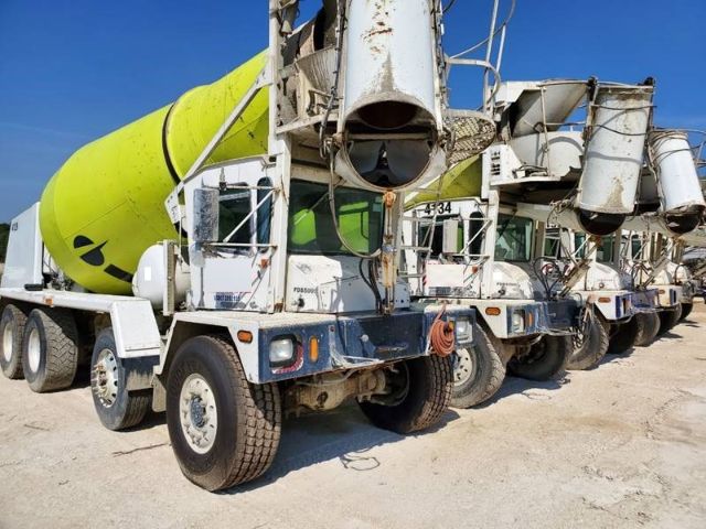 Terex FDB5000 concrete mixer trucks in a row with green mixer drum and white frames.