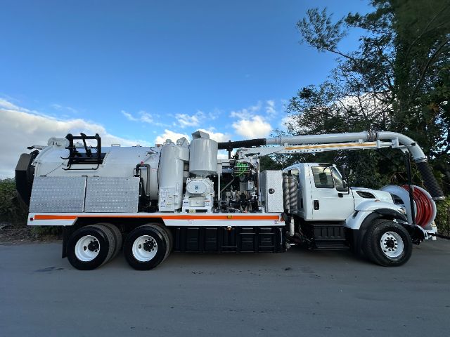 2016 International 7400 vacuum truck with large rear tank, hose reel, and pump system mounted on truck chassis.