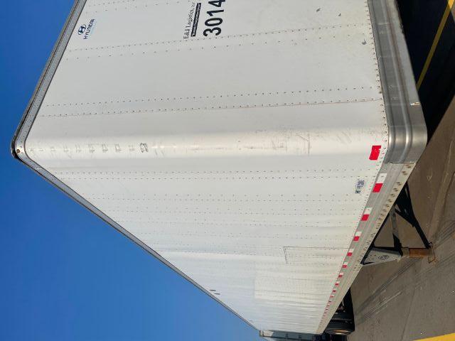 Hyundai trailer side view showing white cargo trailer with ribbed panels and E&L Logistics sticker, part of a 2014 model, long rectangular shape.