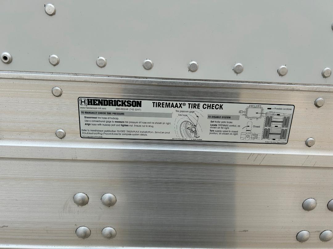 Hendricks on-board TireMaaX Tire Check label with diagrams mounted on an aluminum truck body side panel.