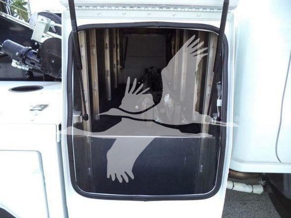 Truck cargo area with open rear door showing interior storage space and hydraulic lift mechanism.