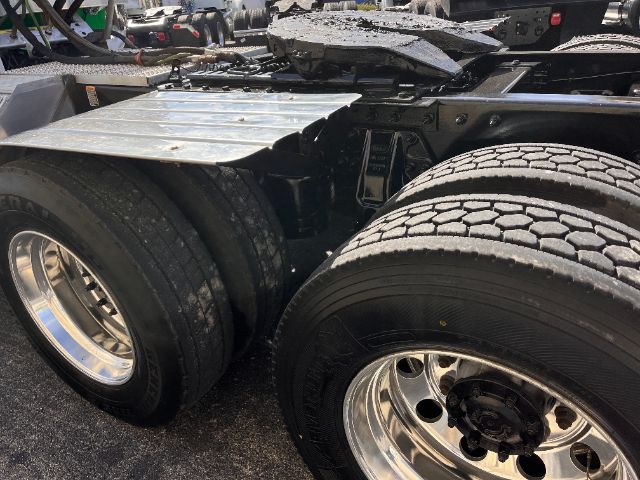 Peterbilt 579 truck chassis with dual rear axles and chrome wheels, showing tires and frame.