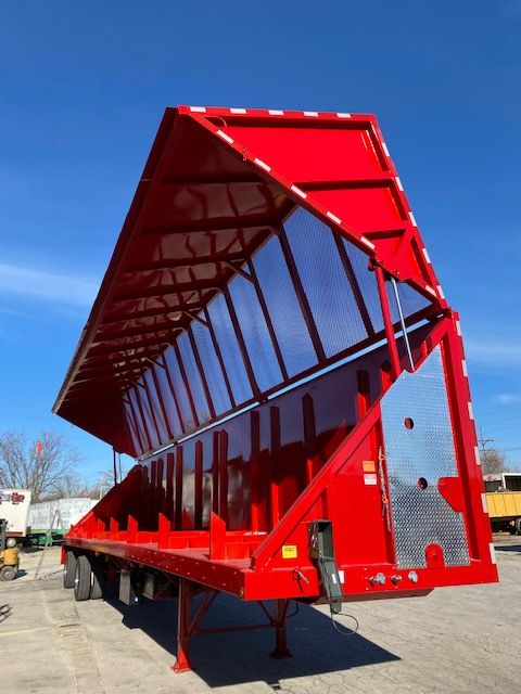 Transcraft 48 ft trailer bed in red with tall sidewalls and a ribbed floor, side ramp up, used status.