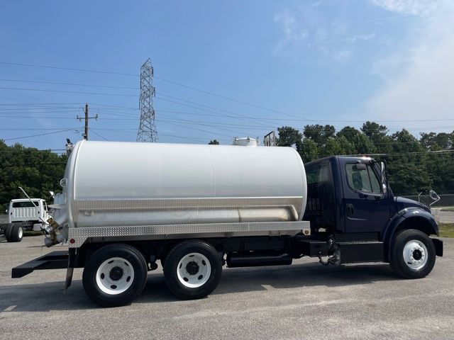 Fleet fuel/sewer service truck with a large cylindrical stainless tank mounted on a heavy-duty three-axle chassis.