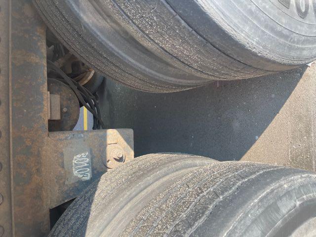 Trailer tandem axle area showing dual tires and undercarriage with a 507 label and wiring harnesses.