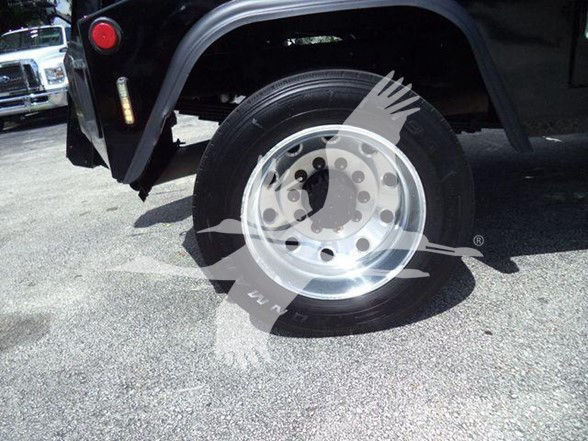 Truck wheel and fender of a 2018 Ram 4500 SLT, showing polished steel rim and tire; visible side panel with fender flare and a small red reflector/marker light.