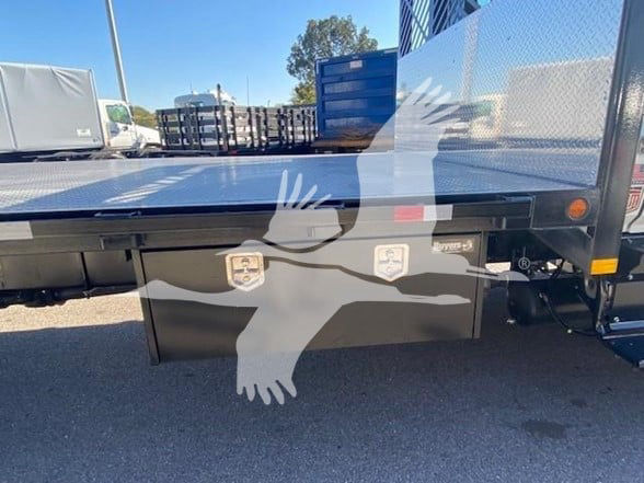 Flatbed truck deck with two toolboxes mounted underneath; Hino branding not visible; metal diamond plate bed; rear area showing two silver latches on black boxes