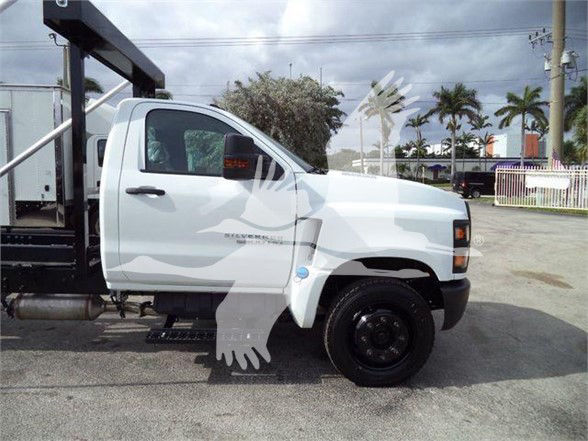 Truck cab of a 2023 Chevrolet Silverado 6500HD in a lot, side view showing front wheel and passenger door.