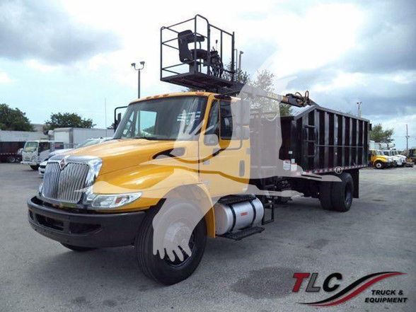 2019 International DURASTAR 4300 dump truck with grapple equipment and yellow cab in a used truck lot.