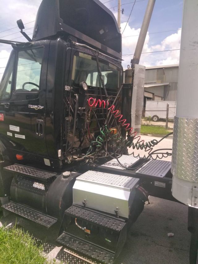 Tractor-style truck cab showing air hoses, side steps, and fuel tanks.