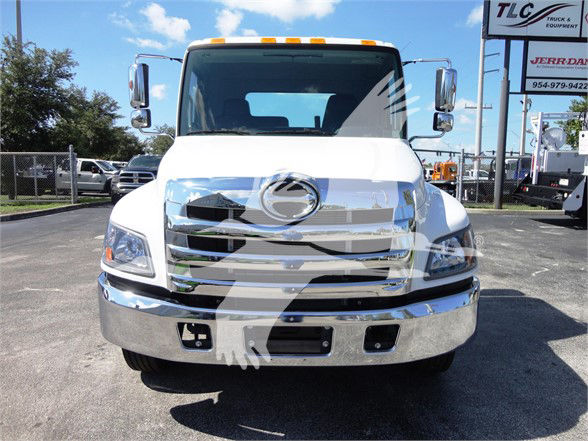 Front view of 2022 Hino 268A tow truck showing chrome grille, bumper, and headlights.