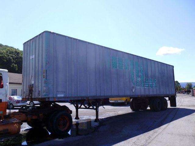 Fruehauf F69-F2-45 trailer connected to truck chassis, side view showing blue weathered container and dual rear wheels.