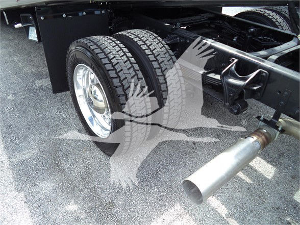 Truck rear dual tires and exhaust visible under chassis of a 2023 Chevrolet Silverado 6500HD.