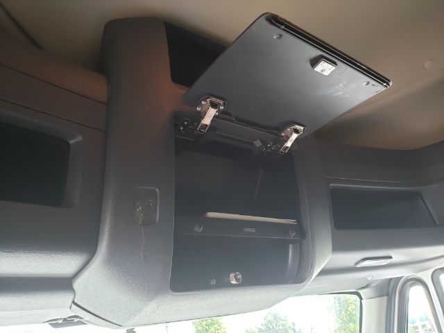 Interior overhead storage compartment of a 2015 International PROSTAR sleeper truck with an open compartment showing shelves.