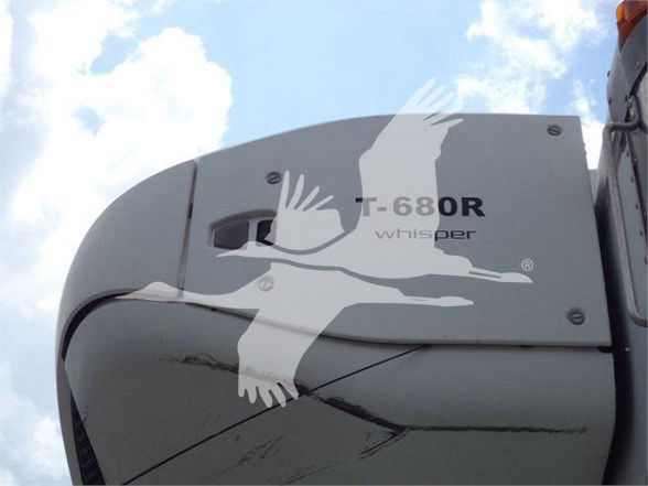 Truck cab corner showing T-680R whisper emblem and swooping design on light gray surface.