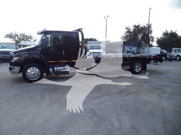 Tow truck: 2024 International MV with flatbed, side mirrors, chrome fuel tank, dual rear wheels, headlights visible.