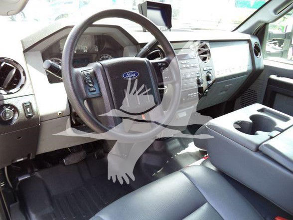 Ford F-550 interior dashboard and steering wheel with center console and cup holders.