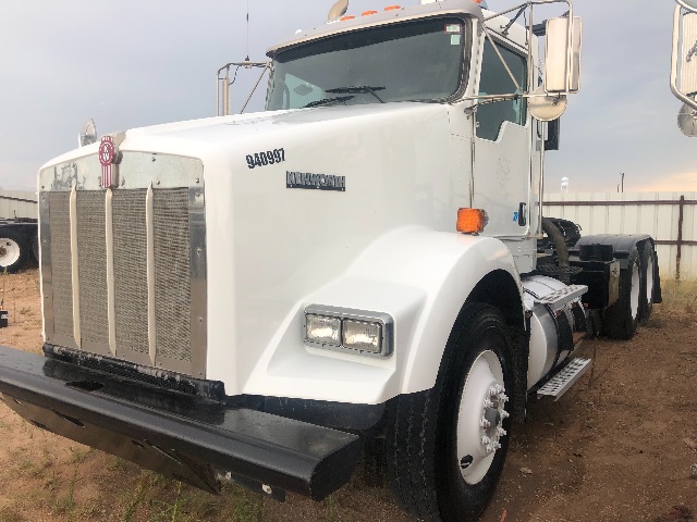 Kenworth T800 vacuum truck cab and front grille with large chrome grille, dual rectangular headlights, white paint, and heavy-duty bumper.