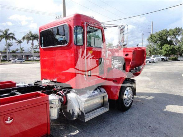 Peterbilt 337 truck cab in red in-service view showing side tank and chassis with cab interior visible through window.