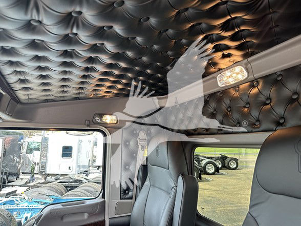 Kenworth W900L truck interior cab showing quilted black headliner, overhead storage, and seating.