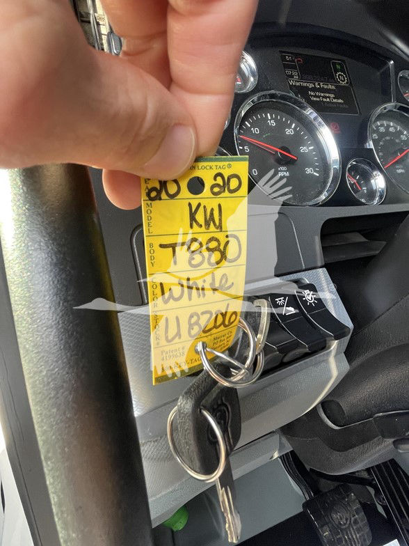 Tag on ignition area with handwritten numbers KW 5880 and 88000? and keys in ignition; dashboard gauges in background
