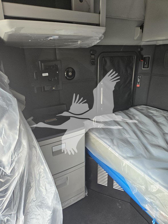 Interior of a 2026 Kenworth T680 cab showing sleeper area with covered cushions, storage drawers, and control panels.