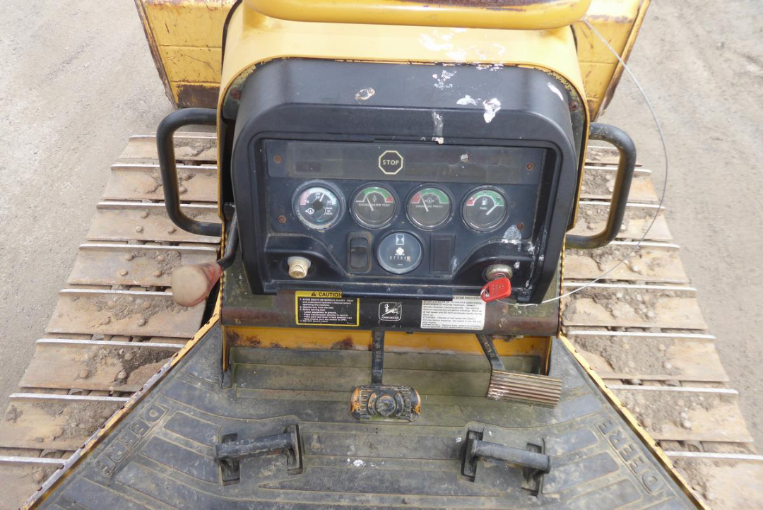 John Deere 650HLT dozer cab controls with gauge cluster and pedals visible.