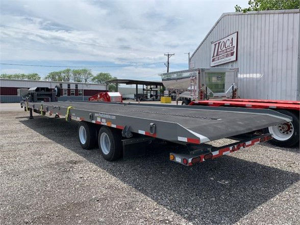 Trailer: 2024 drop deck container delivery trailer with tan tandem axles, flatbed deck, gray paint, red and white reflective markings, stock number 981003 TANDEM DD.
