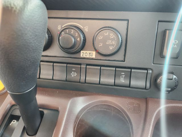 Dashboard area of a 2025 Hino L6 cab and chassis showing climate control dials and various switches.