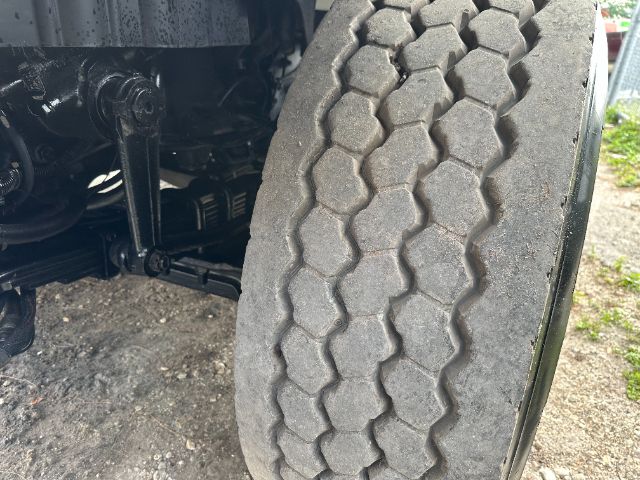Truck front wheel and suspension visible, tire tread pattern in view. No legible labels or fluid containers visible.