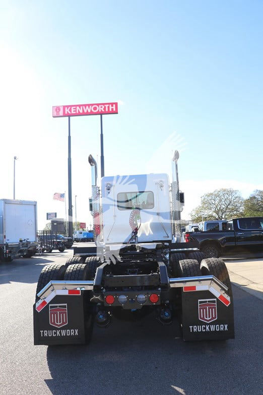 Kenworth W900L conventional daycab rear view showing dual rear axles and mud flaps with TruckWorx branding.