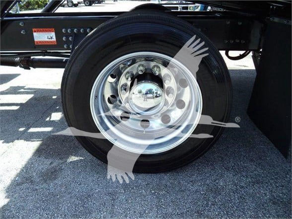 MD6 truck wheel showing polished steel rim and black tire with warning labels on frame.