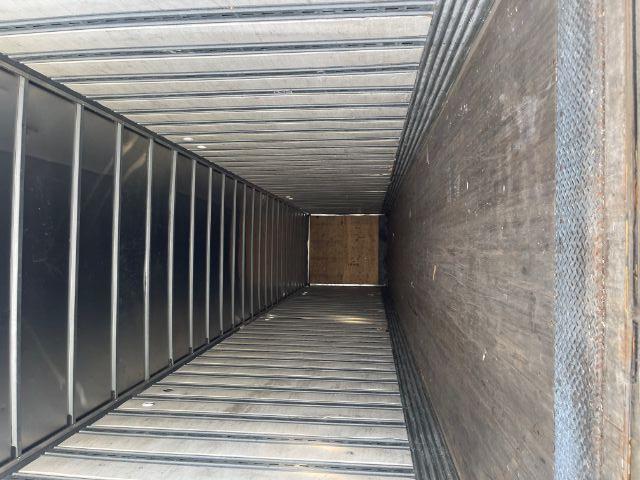 Inside of a long rectangular trailer with metal sidewalls and wooden front bulkhead.