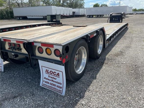 Fontaine double drop deck trailer showing wooden bed and rear lights with ILOCA Rentals sign in the wheel well.