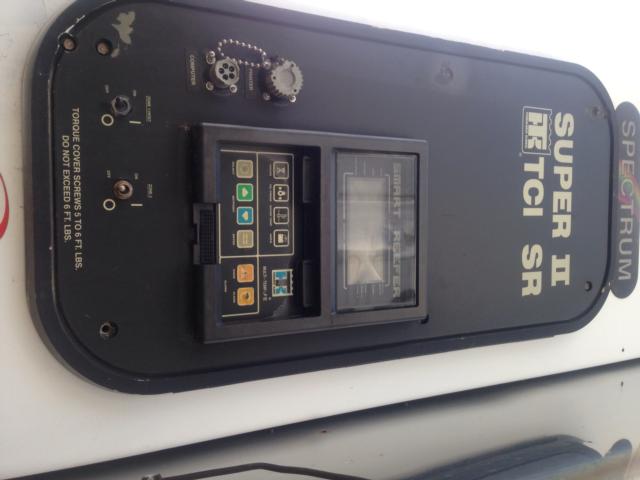 Panel with control keypad and display mounted on a black plate labeled ‘SUPER II RTI SR’ and various gauges/knobs. Small text around edge mentions fuel valve and connectors.