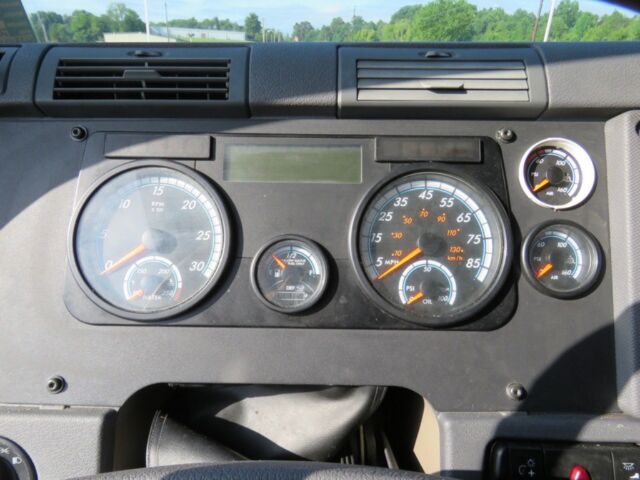 Dashboard gauges of a Freightliner Cascadia Evolution showing speedometer, tachometer, and auxiliary gauges.