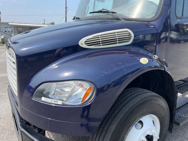 2013 Freightliner M2 front-left view showing blue cab, front grille, rounded hood with vent, headlight, and front tire.
