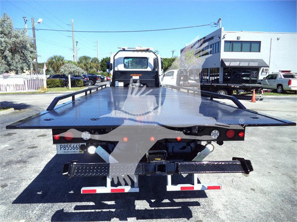 Isuzu FTR tow truck flatbed rear view showing hydraulic bed and bumper lights.