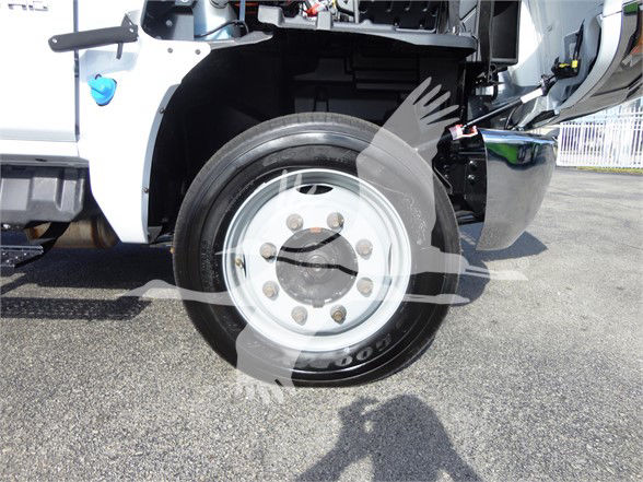 Front wheel of a 2023 Chevrolet Silverado 5500HD dump truck showing steel rim and tire with visible lug nuts and hub.